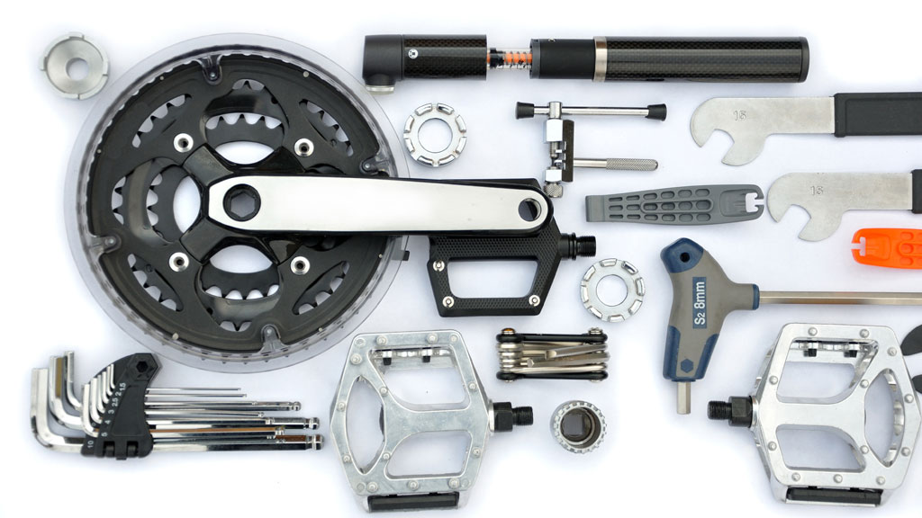 Kit réparation vélo compact disposé sur table en bois avec multi-outil et chambres à air