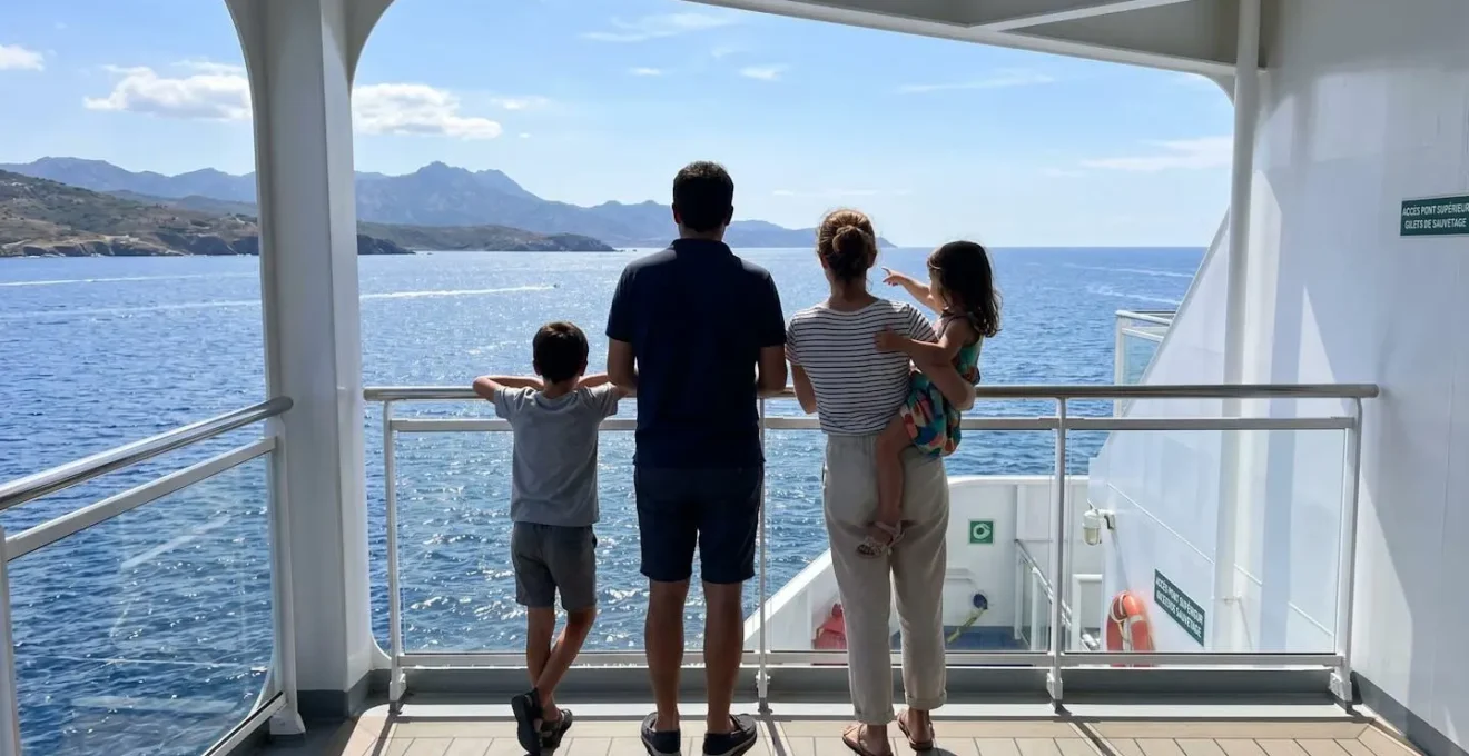 Une famille de quatre personnes vue de dos regarde ensemble la mer Méditerranée depuis le pont d'un ferry moderne par une journée ensoleillée