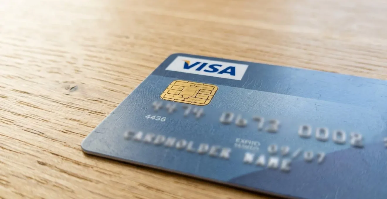Gros plan macro sur une carte bancaire Visa moderne avec puce EMV visible en mise au point nette, posée sur une surface contemporaine claire avec arrière-plan flouté